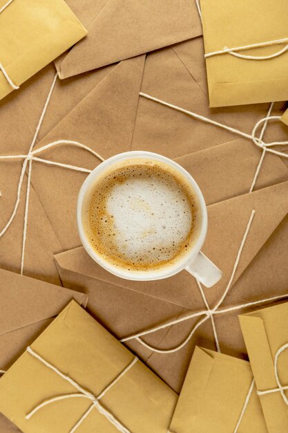 White minimal cop of coffee on lots of vintage craft envelopes and Santa letters. Christmas hot drink concept.