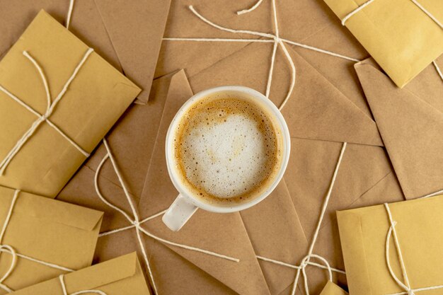 White minimal cop of coffee on lots of vintage craft envelopes and santa letters christmas hot drink...