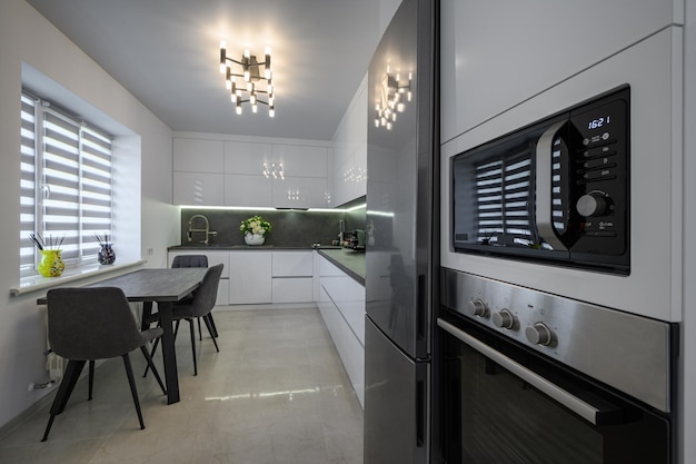 White modern kitchen with granite counter top and marble floor