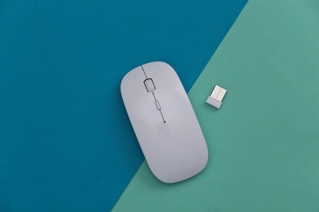 White modern wireless pc mouse on colored background. Top view