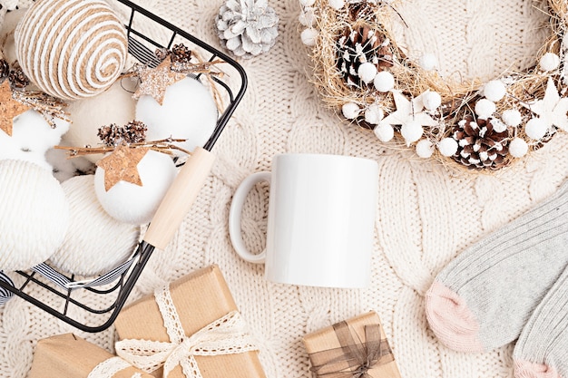 white mug and eco friendly Christmas ornaments. Assortment of cozy hygge Xmas decorations with copy space for text on blank cup. Flat lay, top view