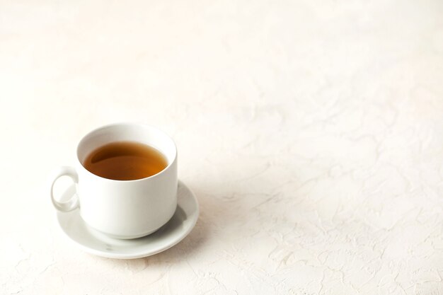 White mug with tea on a light background with a place to enter text