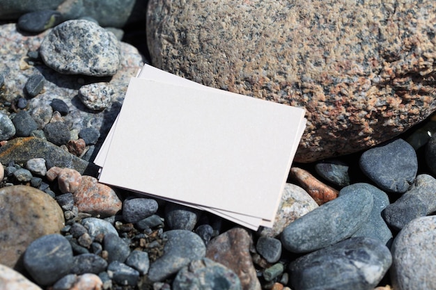 A white note is laying on a beach with rocks and pebbles.