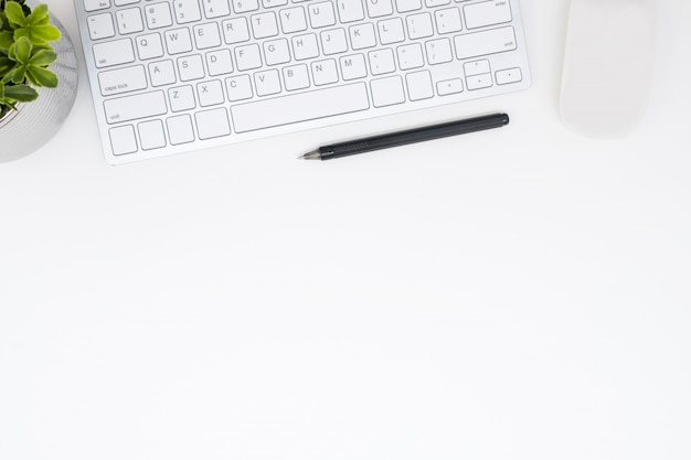  White office desk table with computer gadgets and pen. Top view with copy space, flat lay.