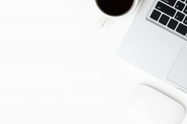 White office desk table with laptop, mouse and cup of coffee. Top view with copy space, flat lay.