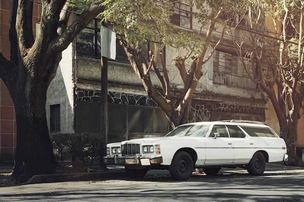 White old classic car parked on the side of the street next to residential house Mexico City