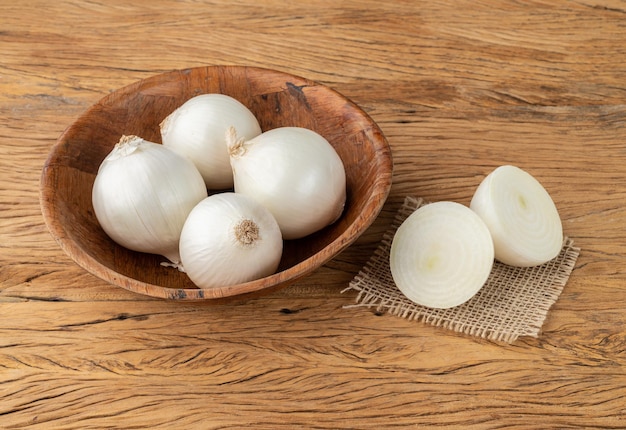 White onions in a bowl over wooden table