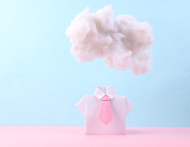 White origami shirt with floating fluffy cloud on pastel pink blue background Creative idea Minimal concept Pastel color trend