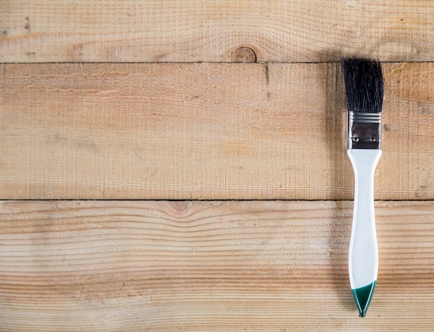 Photo the white paint brush on wooden background