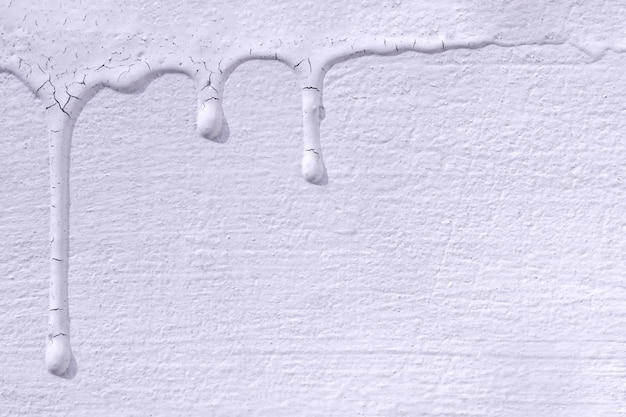 White paint stains with cracks on the white concrete wall.