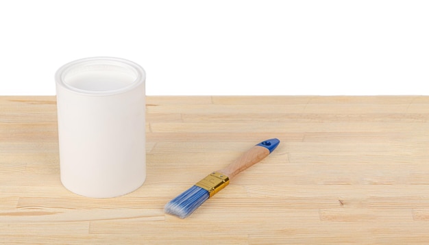 White paint with a brush on a wooden background with texture