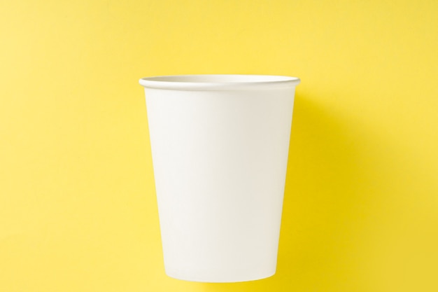 White paper cup on a yellow background. Top view.Ecology concept