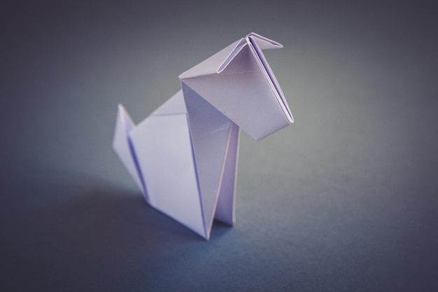 White paper dog origami isolated on a grey background