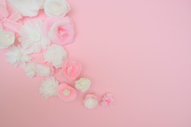 White paper flowers on pink background. Cut from paper.