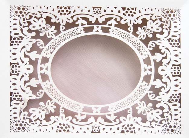 White paper hollow lace oval frame, done in the ornate and luxurious style on a pink background