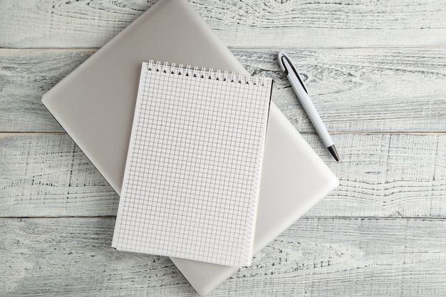 White paper Notepad and laptop on vintage shabby 