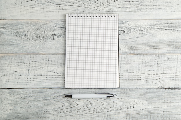 White paper Notepad and white pen on vintage shabby on wooden table