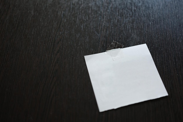 White paper pad on black wooden table space for text