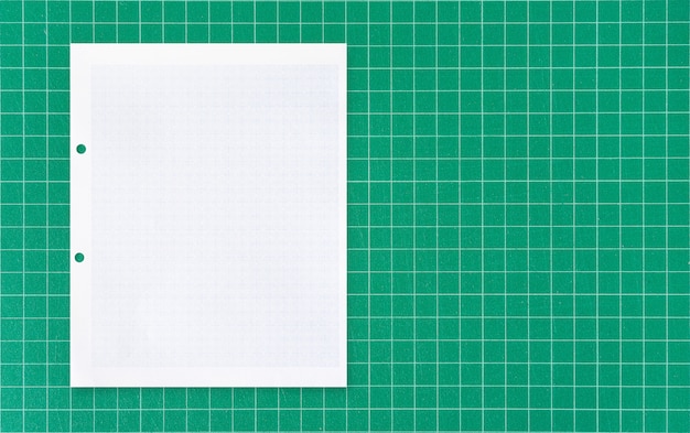 White paper sheet on green mat.