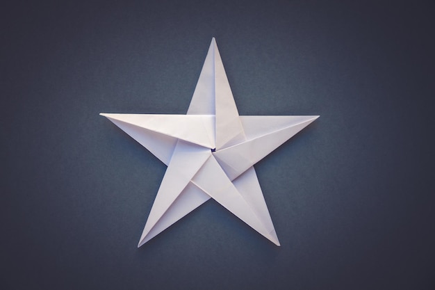 White paper star origami isolated on a grey background