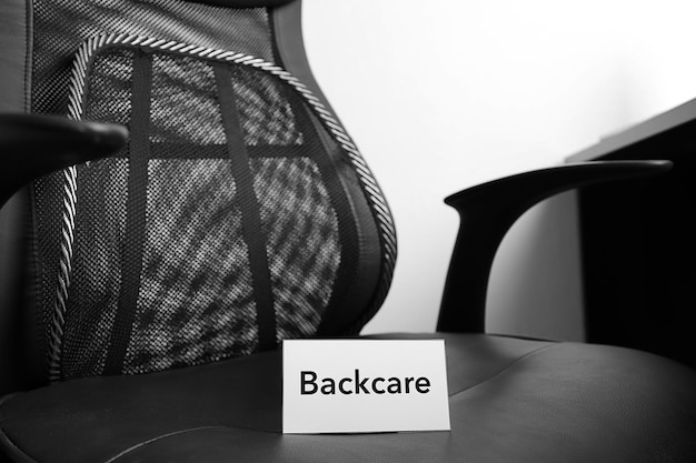 White paper with word BACKCARE on black office chair