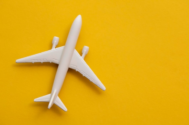 White passenger airplane on a summer yellow background. Travel and vacation background.