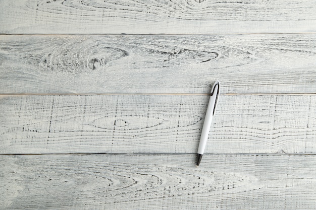 Photo white pen on vintage shabby white wooden background. the view from the top. flat lay