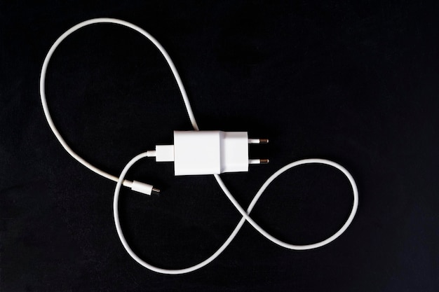 White phone charger closeup on a black background copying space