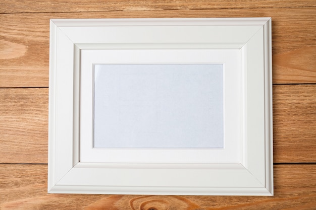 White photo frame on wooden wall