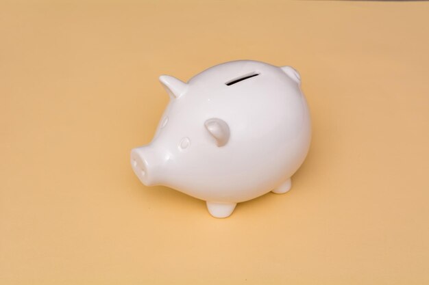 White pig piggy bank on a beige background