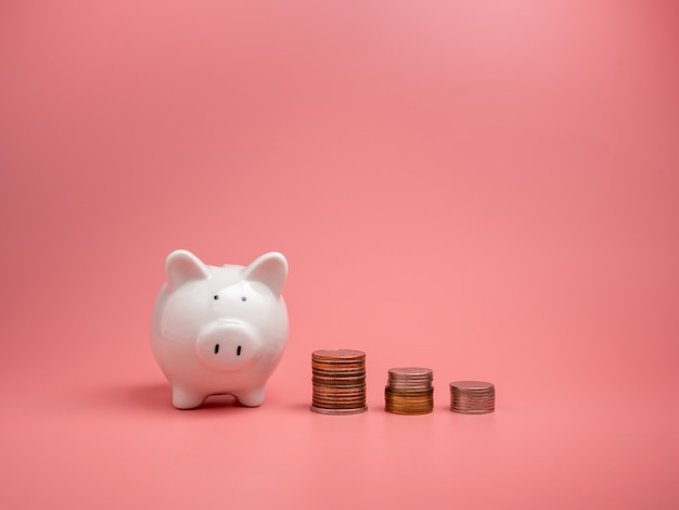 White piggy Bank and coins piles isolated