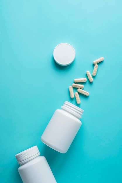 White pill bottles on blue background Health care food supplements vitamins and medicaments