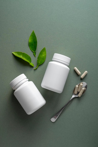 White pill bottles on green background Health care food supplements vitamins and medicaments