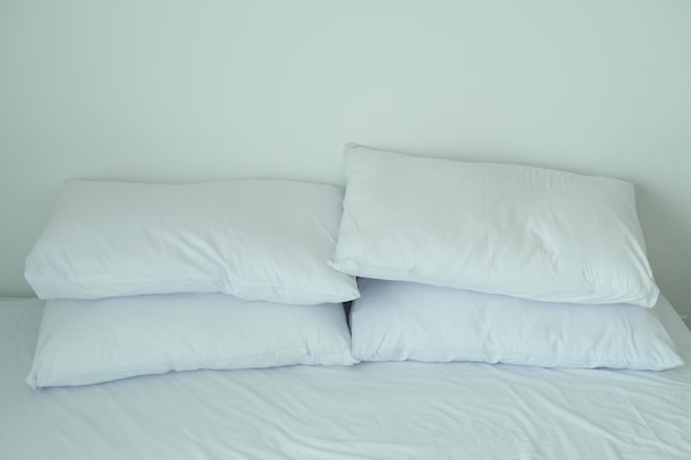 White pillow lined up on bed