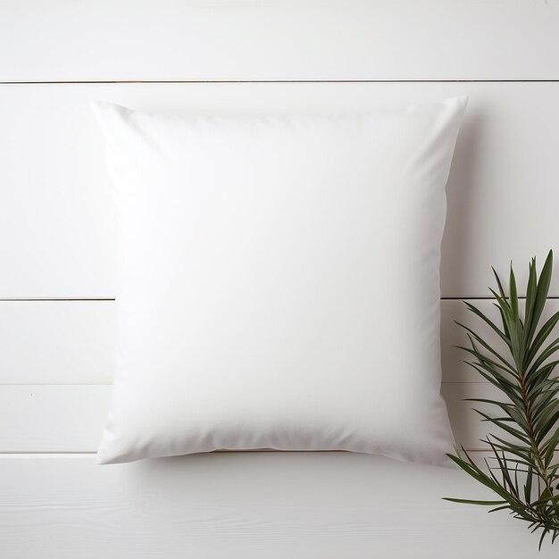 Photo a white pillow with a green plant next to it