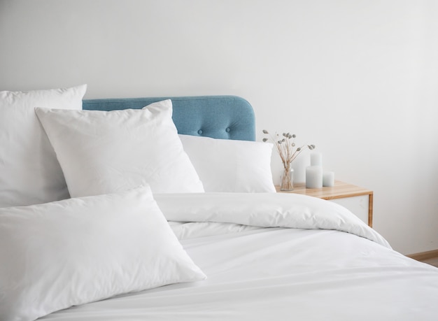 White pillows and duvet on the blue bed.