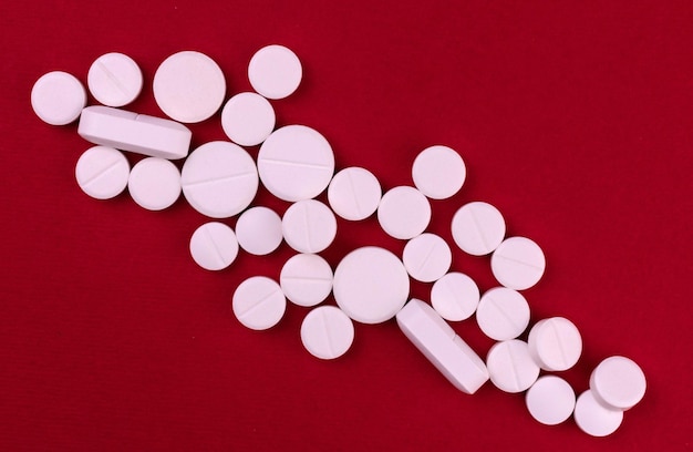 white pills on a red background Top view