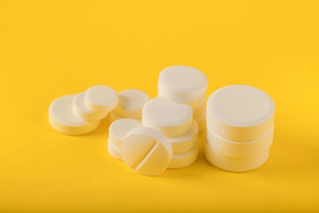 White pills on yellow background