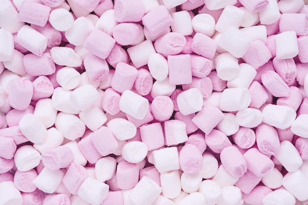 white and pink marshmallows in the shape of cylinders for drinks and desserts decor food background