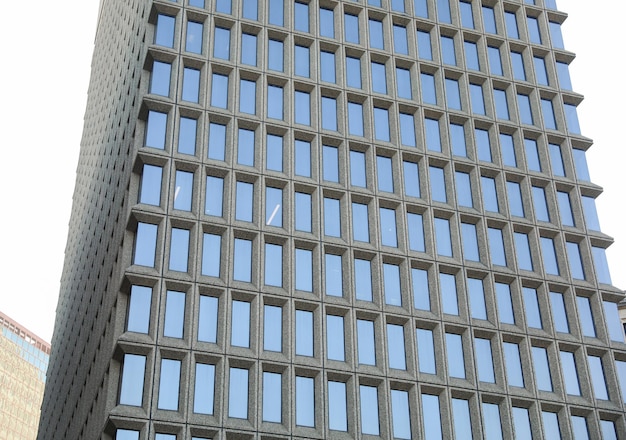 A white plane flies over a building in downtown chicago.