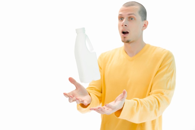 A white plastic bottle flying above the men's hands is isolated on a white background A surprised man with an open mouth Object One Pack Person