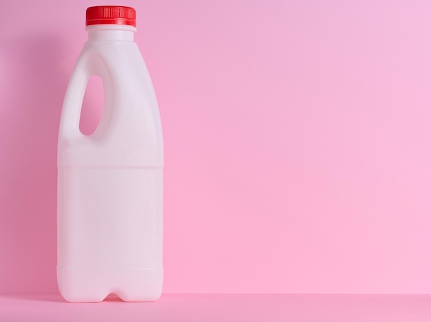 White plastic bottle for milk and dairy products on a pink background