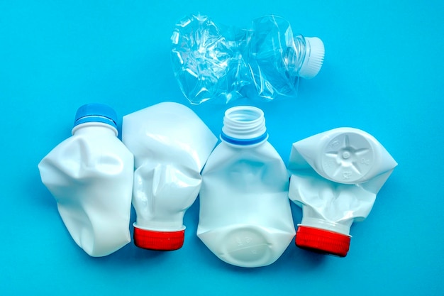 White plastic bottle on a solid blue background for recycle waste Waste separation concept Protect the environment Secondary raw material Sorting garbage concept Selective focus