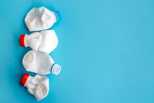 White plastic bottle on a solid blue background for recycle waste Waste separation concept Protect the environment Secondary raw material Sorting garbage concept Selective focus