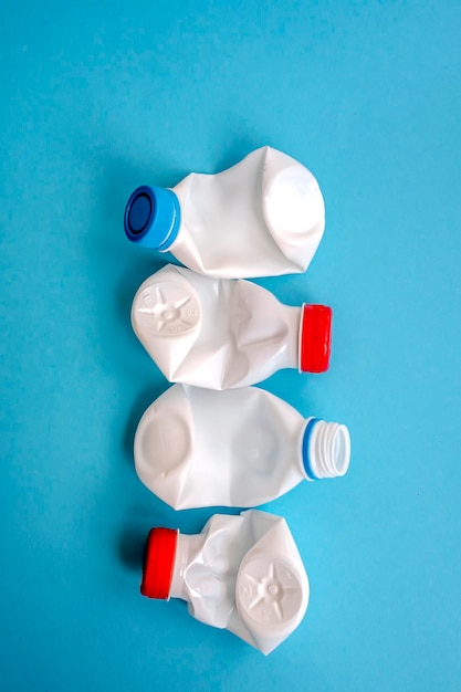 White plastic bottle on a solid blue background for recycle waste Waste separation concept Protect the environment Secondary raw material Sorting garbage concept Selective focus