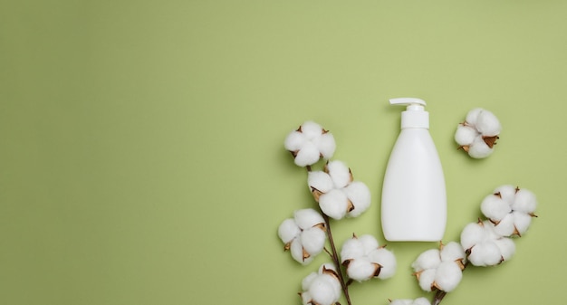 White plastic bottle with pump on a green background Containers for cosmeticsx9