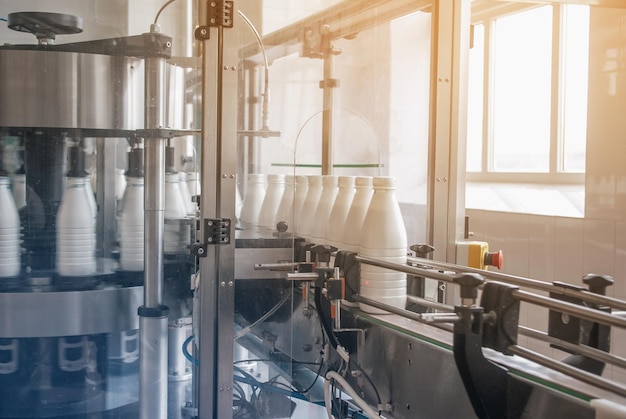 White plastic bottles with dairy product on the production line Bottled on conveyor