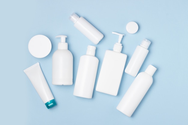 White plastic cans on a blue background. Cosmetics for skin care. Detergents, disinfectants and laundries.