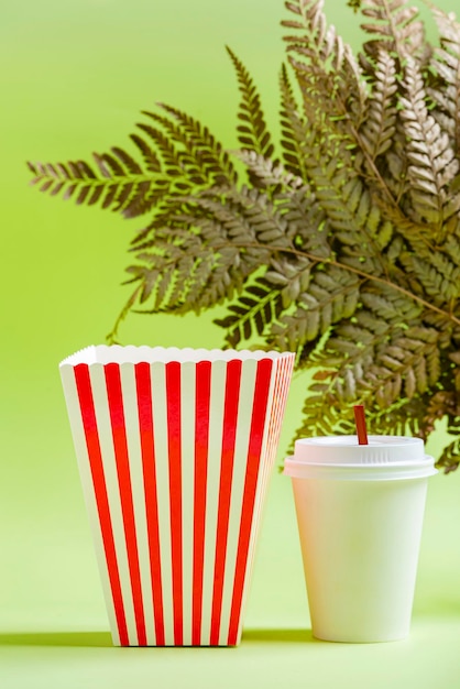 White plastic cup and paper container with colored background