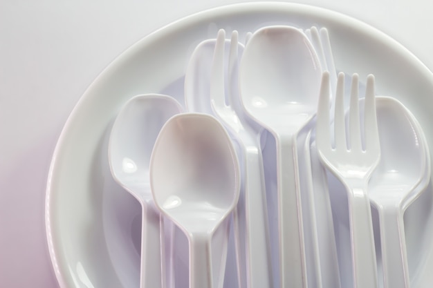 White plastic disposable tableware on white background